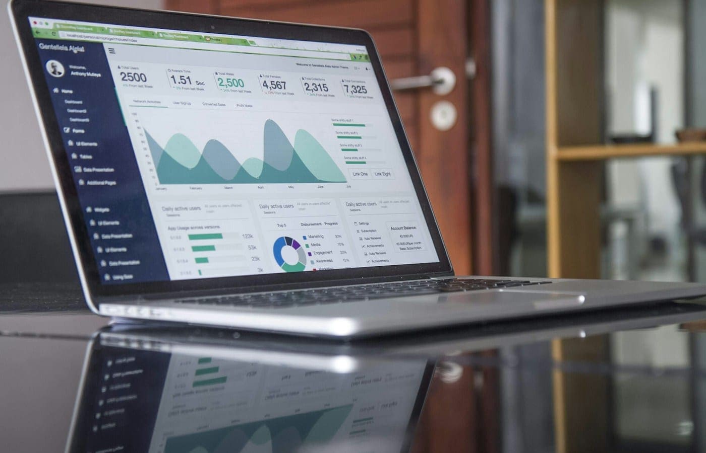 Ordinateur portable affichant un tableau de bord de statistiques sur un bureau